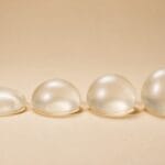 Four round silicone breast implants of the same width and increasing projection in a row, from low profile to ultra-high profile