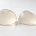 Round and teardrop-shaped silicone breast implants side by side, teardrop vs round implants
